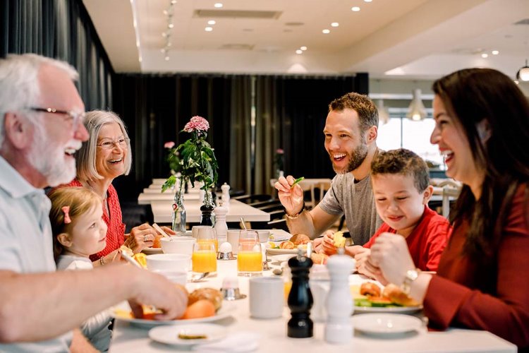 Perhe syö aamiaista hotellilla