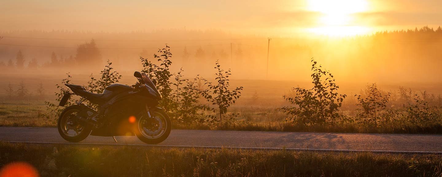 Moottoripyörä parkissa tienvarressa auringonnousun aikaan