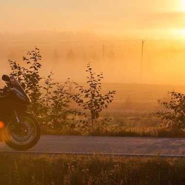 Moottoripyörä parkissa tienvarressa auringonnousun aikaan